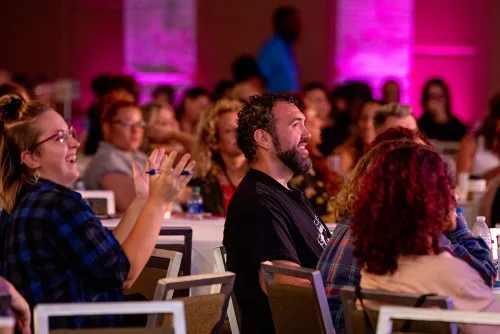 Owners sharing a laugh in the audience at a Strategies event